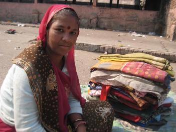 Jamna selling old clothes in a mandi near Raghubir Nagar